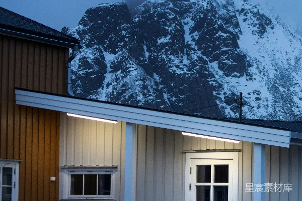 高清摄影 一座木屋，背后是被雪覆盖的山。