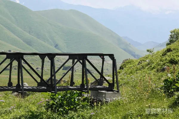 高清摄影 一座金属桥横跨在绿色的山谷上。