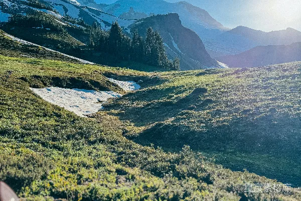 高清摄影 阳光照亮了覆盖着雪斑的草地山景。