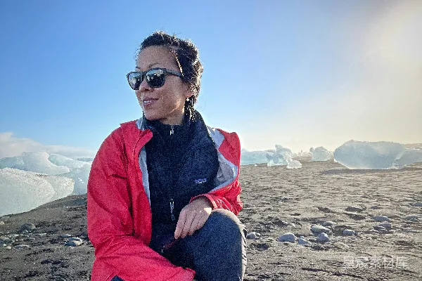 高清摄影 一个女人坐在沙滩上。