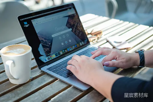 高清摄影 在棕色木桌旁使用MacBook Pro的人