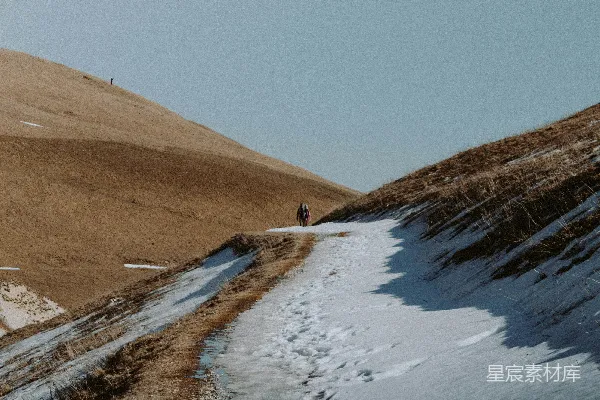 高清摄影 两个人走在覆盖着雪的泥土小路上