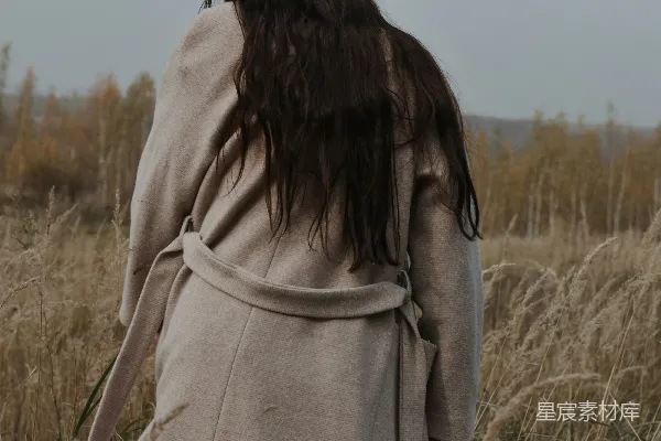 高清摄影 一个女人在一片高草丛中行走。