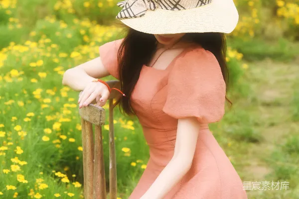 高清摄影 戴着帽子的女人靠在一个田里的柱子上。