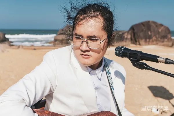 高清摄影 一个女人在海滩上弹吉他
