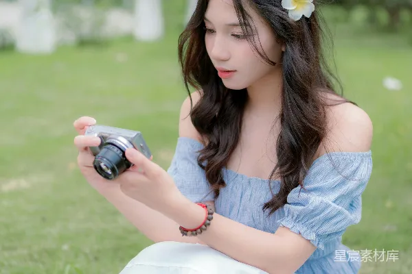 高清摄影 一个女人坐在地上拿着相机。