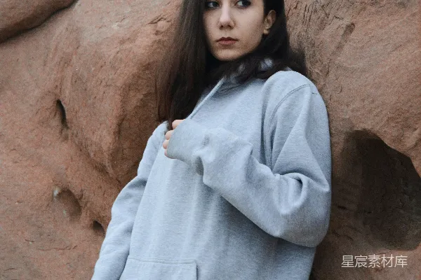 高清摄影 一个女人靠在沙漠中的岩石上。