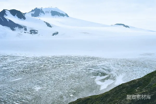 高清摄影 男人在雪地里行走，面向着山峰。