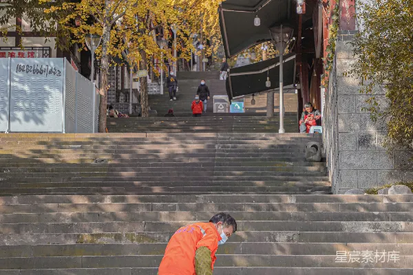 高清摄影 一个穿着橙色连体衣的男人正在捡起一个篮子。