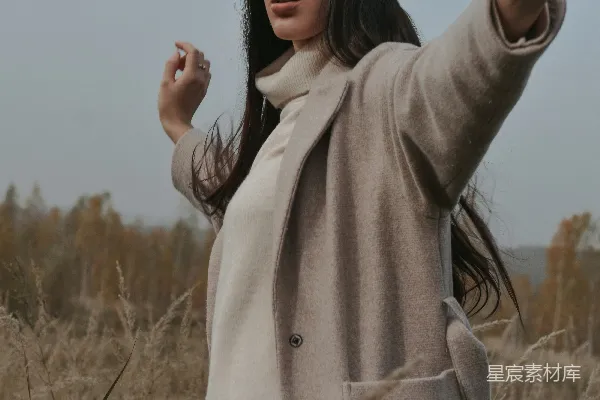 高清摄影 一个女人站在田野里指着什么东西。