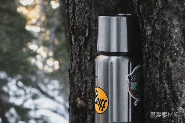 高清摄影 一个水瓶放在雪地里的树旁边。