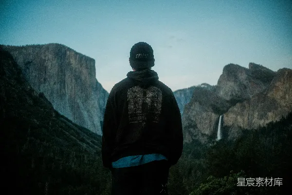 高清摄影 一位站在山前瀑布旁的男人