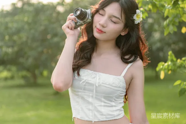 高清摄影 穿着白色连衣裙的女人手里拿着相机