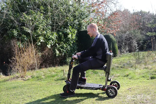 高清摄影 一个人在户外的草地上骑着一辆机动轮椅。
