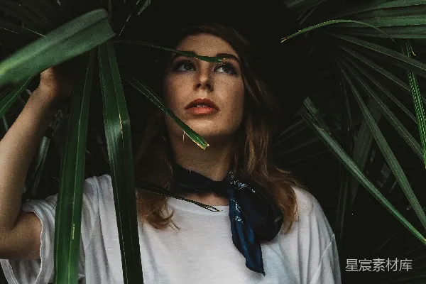 高清摄影 穿着白色圆领衬衫的女人拿着植物