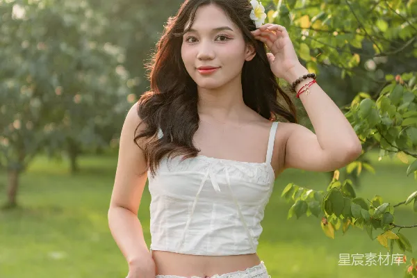 高清摄影 一位穿着白色连衣裙的女士正在摆姿势拍照。