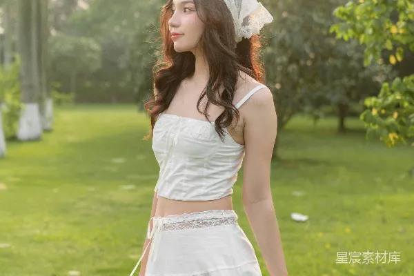 高清摄影 一个穿着白裙的女人站在草地上
