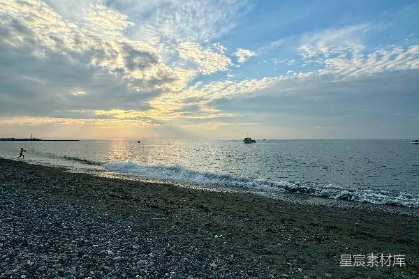 高清摄影 一条岩石和水相间的海滩，在多云的天空下。