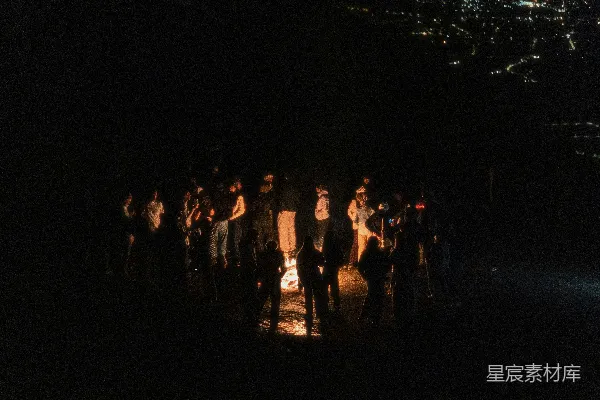 高清摄影 一群人围坐在夜晚的篝火旁。