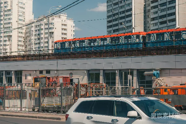 高清摄影 一辆银色吉普车在高楼旁边的路上行驶。