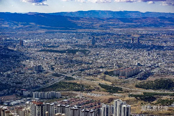 高清摄影 一座城市的空中俯瞰图，背景是山脉。