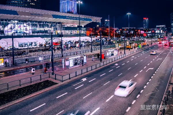高清摄影 一条夜晚的市街，车在上面行驶。