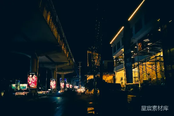 高清摄影 一条夜晚的城市街道，背景中有一座桥。