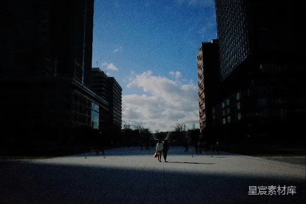 高清摄影 白天，人们走在高楼大厦附近的人行道上。