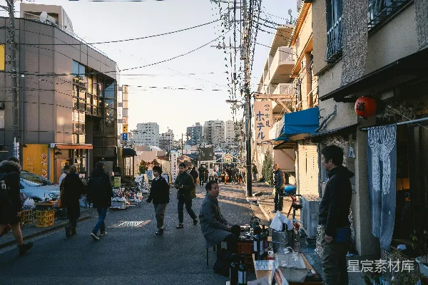高清摄影 一群人沿着街道走过，两旁是高楼大厦。