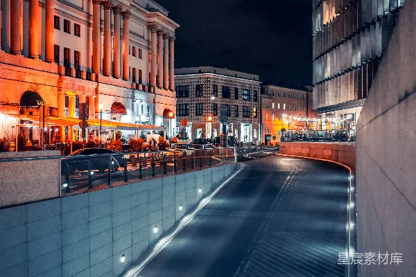 高清摄影 一条夜晚的城市街道，建筑物灯火通明。