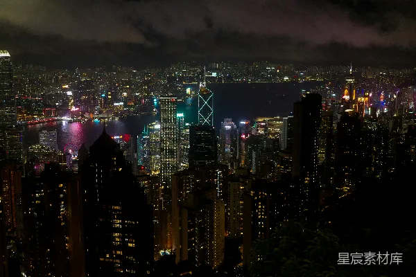 高清摄影 夜色中的繁华城市景观，灯火辉煌的摩天大楼和远处的水体。