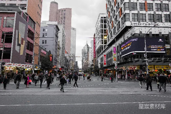高清摄影 一群人正穿过高楼大厦旁的街道。