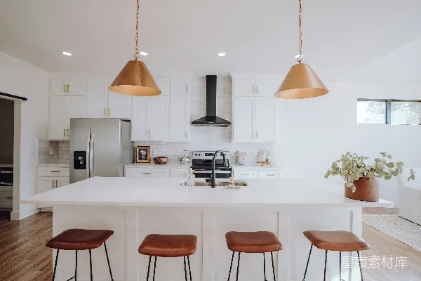 高清摄影 一个厨房里有三个吧台凳和一个中央岛台。