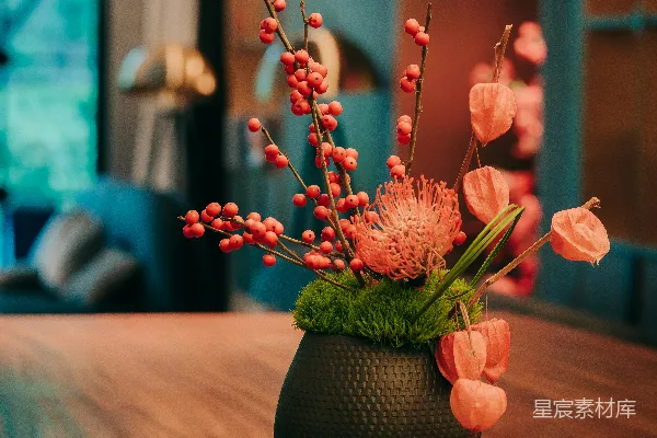 高清摄影 一个黑色的花瓶上插着粉红色的花，放在木桌上。
