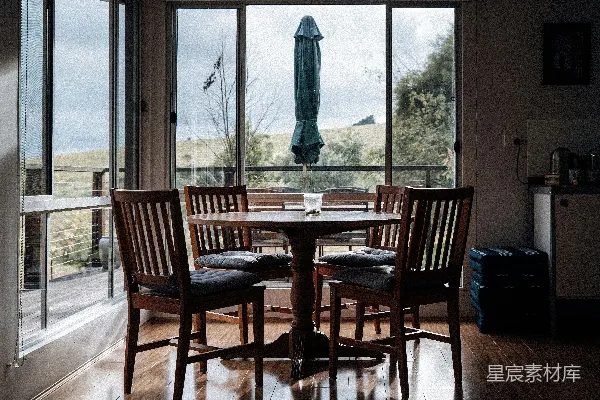 高清摄影 一张餐桌，配有椅子和一把雨伞。