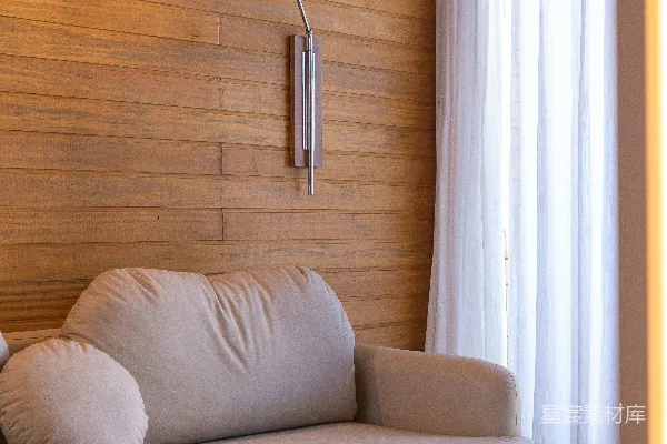 高清摄影 一个舒适的沙发放在木板墙的房间里。