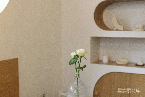 高清摄影 白玫瑰花放在透明玻璃花瓶里，摆在白色的木制架子上。