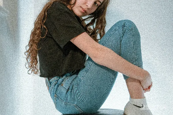 高清摄影 穿黑色长袖衬衫和蓝色牛仔裤的女人坐在白色的椅子上。