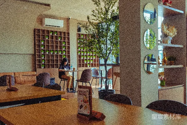 高清摄影 宽敞的咖啡馆内部，配有木质家具和绿色墙面装饰。