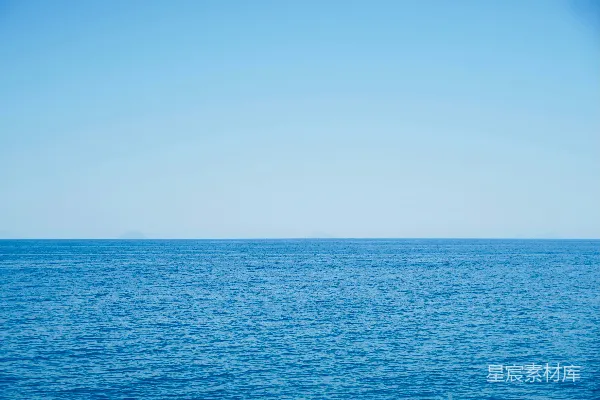 高清摄影 平静的蓝色大海延伸至天际，在晴朗的天空下。
