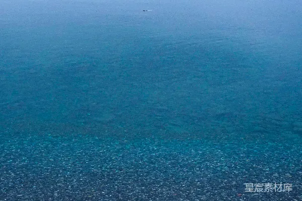 高清摄影 一张长椅坐落在岩石海滩上，旁边是大海。