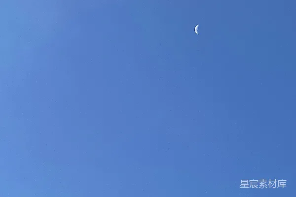 高清摄影 湛蓝的天空中有一轮半圆的月亮。