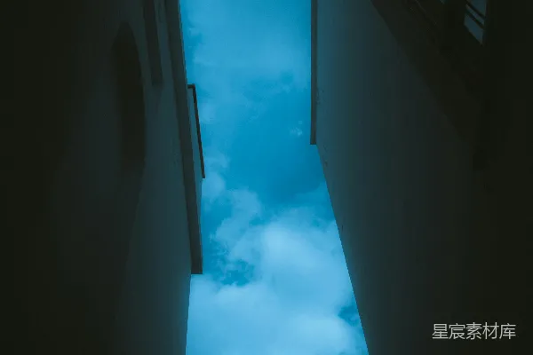 高清摄影 一条狭窄的走廊通往布满云朵的天空。