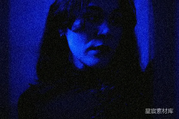 高清摄影 一个女人站在一个黑暗的房间里，有蓝色的光线。