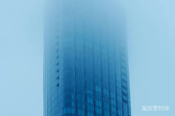 高清摄影 一座非常高大的建筑物，身后是浓雾弥漫的天空。