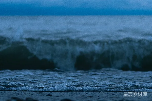 高清摄影 一个拿着冲浪板的人站在海滩上。