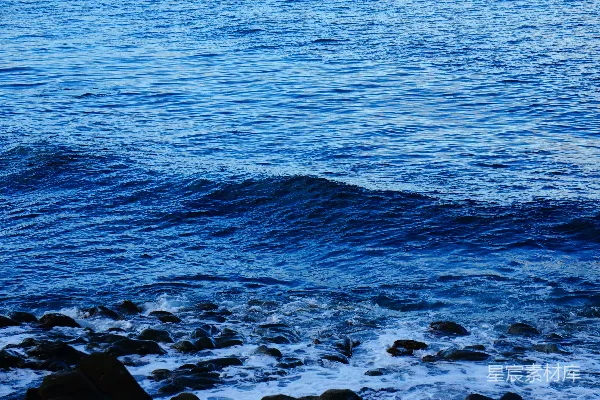 高清摄影 深蓝色的海浪拍打着岩石岸。