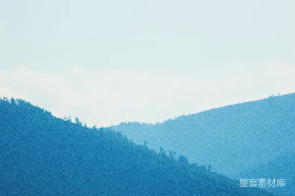 高清摄影 一座山脉的远景，前景中有一些树木。