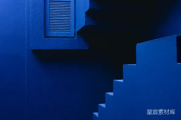 高清摄影 一座建筑内的蓝色楼梯通向一扇窗户。