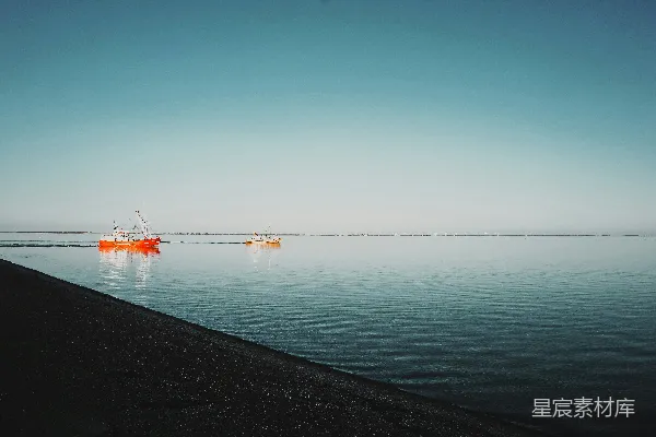 高清摄影 白天，蓝天下的海面上有一艘红色的小船。